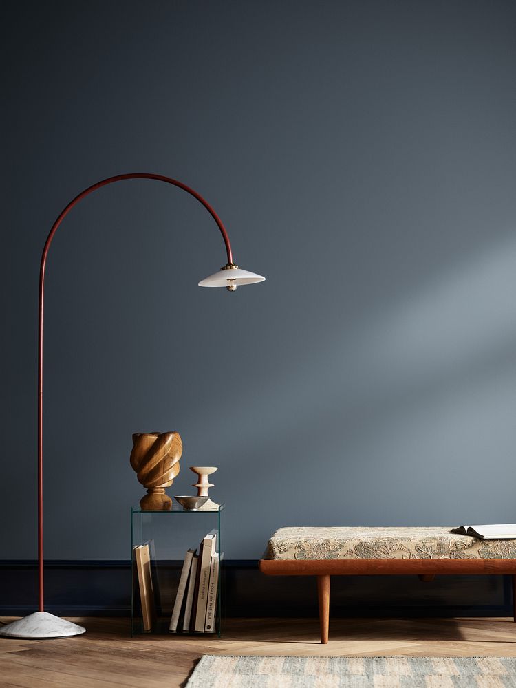 Rom med benk, hyll og stålampe som står mot en matt blå vegg i fargen Byge fra Jotun. Høyt listverk i den mørkeblå fargen Midnight Blue.