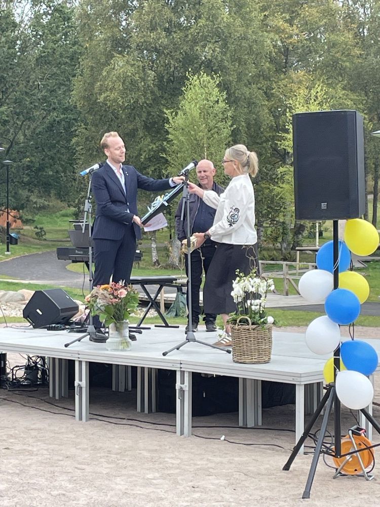 Kommunstyrelsens ordförande Tobias Pettersson räcker över en invigningsgåva till rektor Helen Ling.