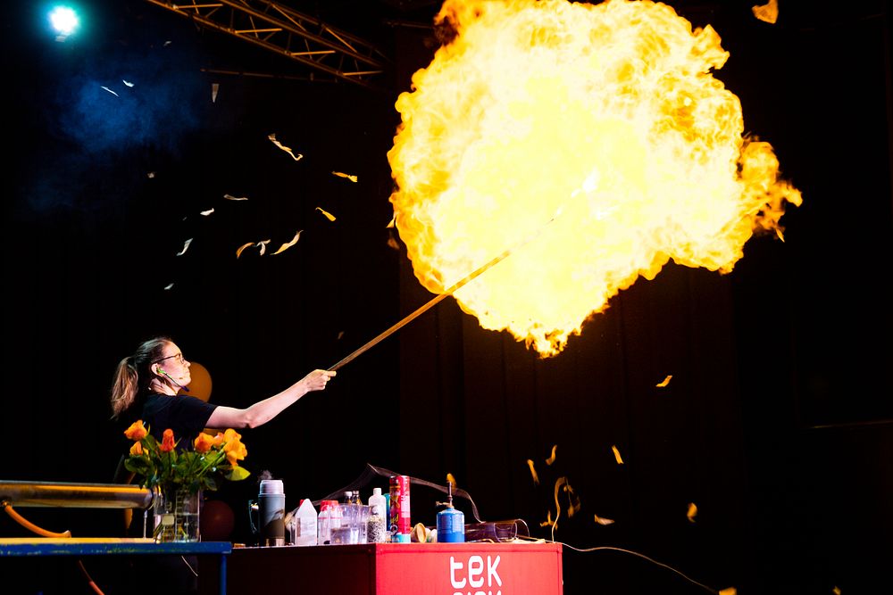 Jente under vitenshowet med eksplosjon av en ballong i flammer