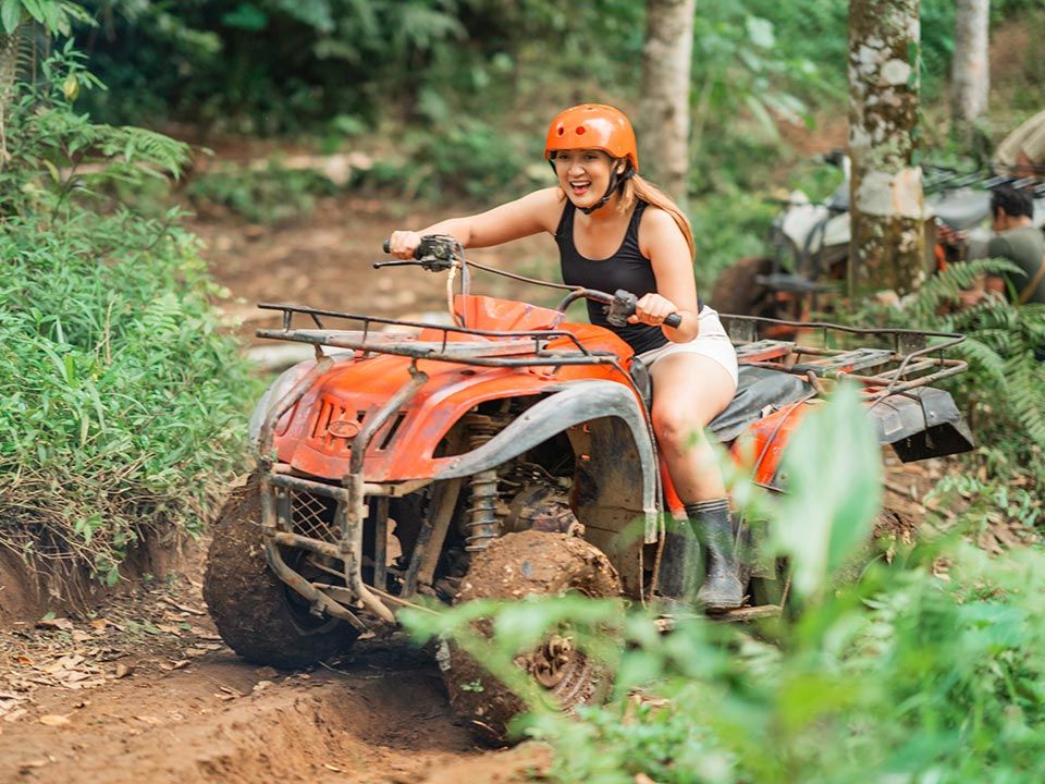 Woman is riding ATV in the jungle