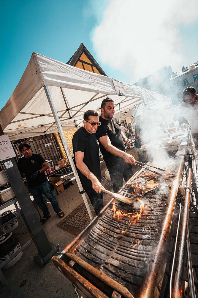 Kokker griller mat utendørs.