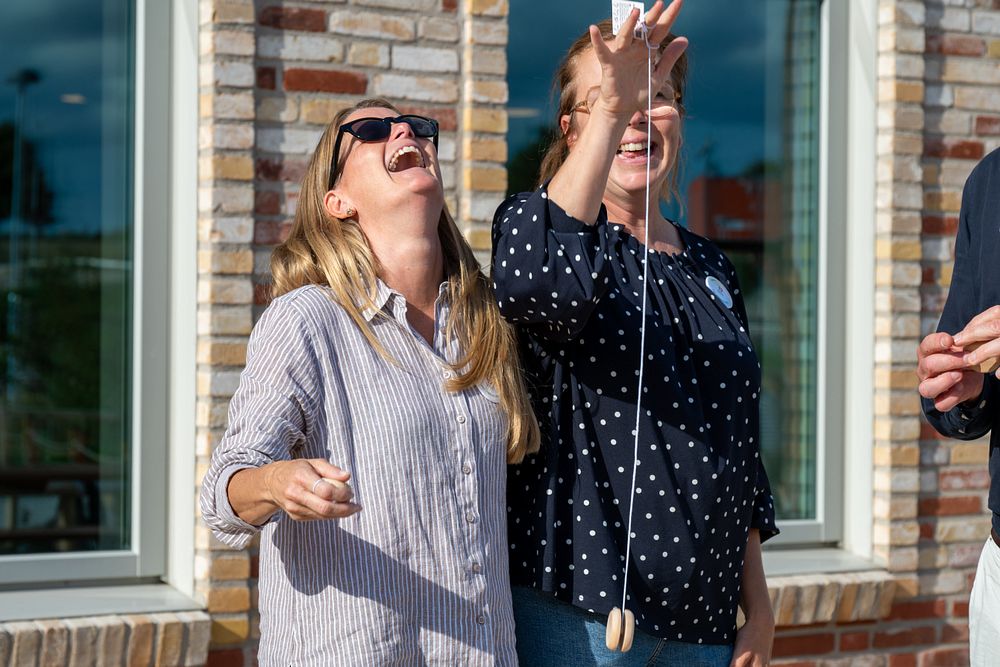 Två kvinnor som står bredvid varandra och håller upp en jojo.
