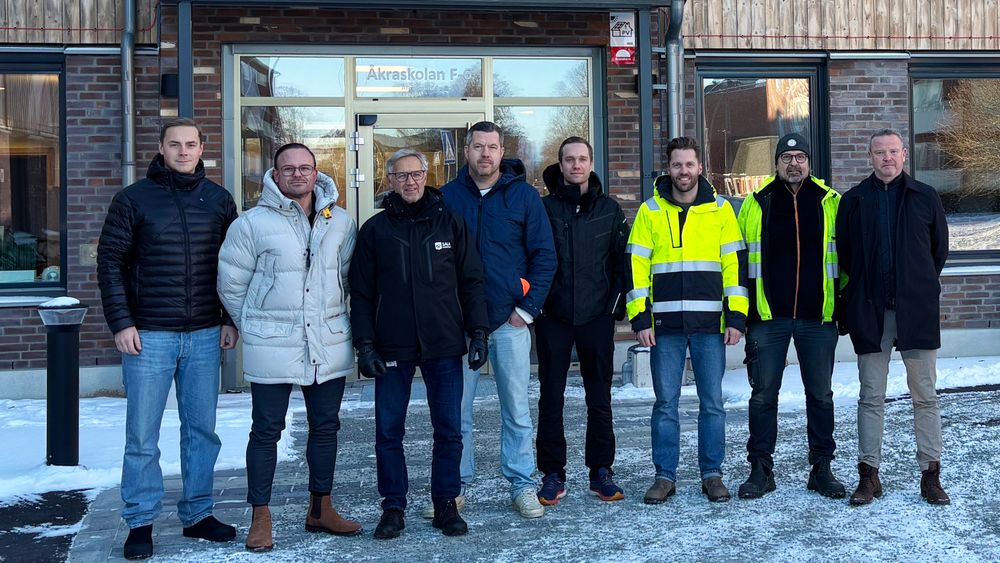 Projektledningen för Åkraskolan framför de färdigställda byggnaden.