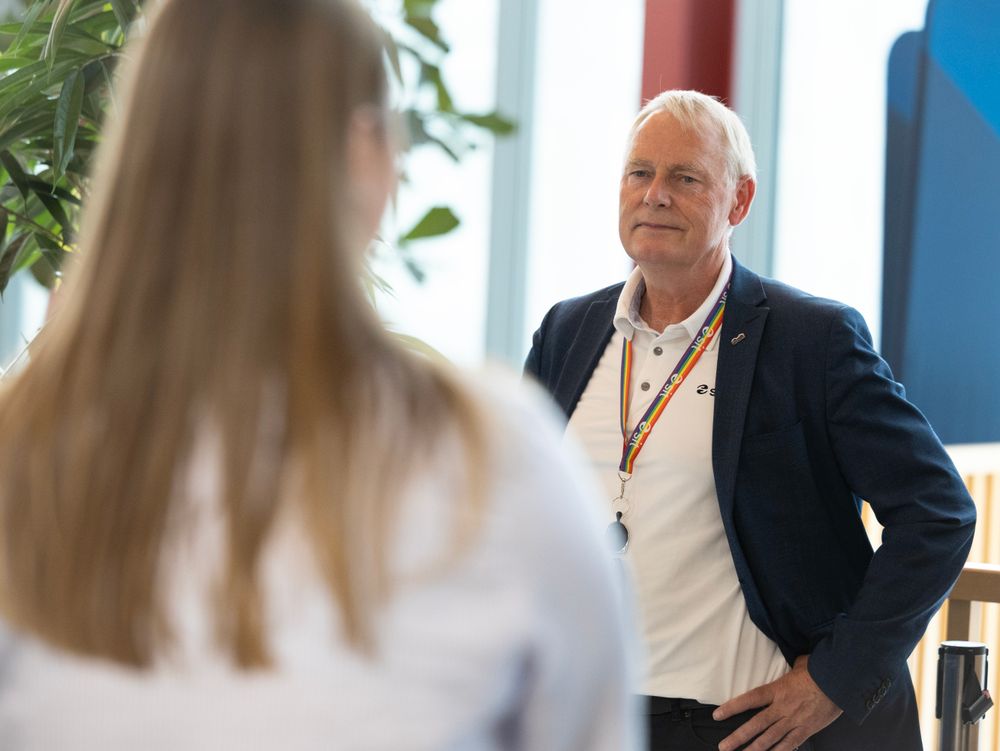 En mann i dress snakker med en student under signeringen av avtalen i dag.