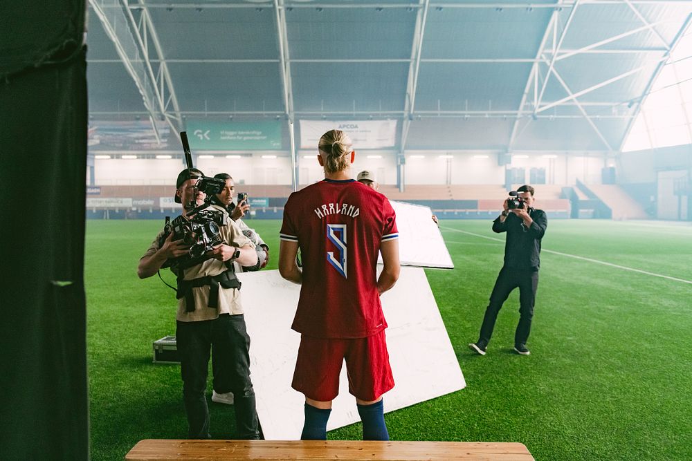 Erling Haaland behind the scenes in the Norwegian Seafood Council’s new videos, football field in the background.