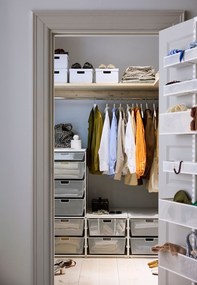 Begehbarer Kleiderschrank mit hängender Kleidung, Regalböden, Aufbewahrungsboxen und Gitterkörben, die die gesamte Raumhöhe nutzen.