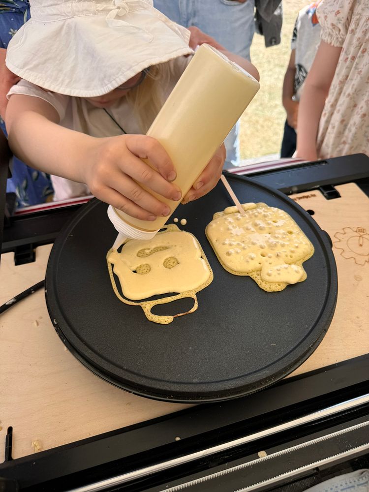 Jente lager pannekake med roboten PancakeBot.com