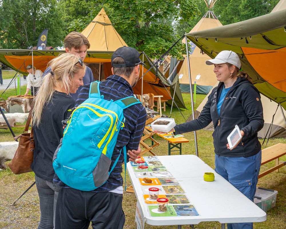 En kvinne som viser fram noe til et publikum.